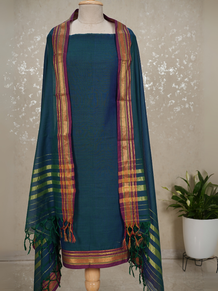 Teal dress with a colorful scarf on a mannequin against a light background